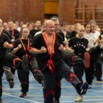 Uczestnicy seminarium sztuk walki cwiczacy kopniecie proste